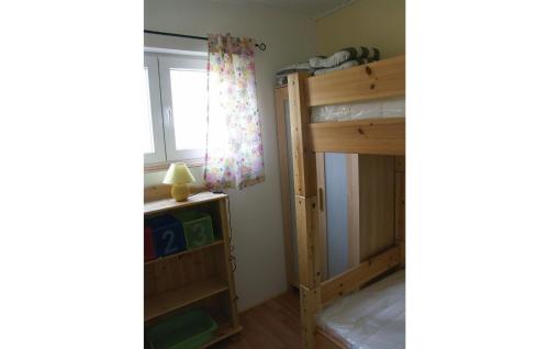 1 Schlafzimmer mit 2 Etagenbetten und einem Fenster in der Unterkunft Ferienhaus Seeigel M in Süssau