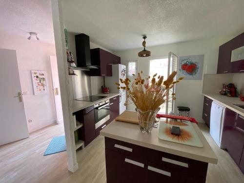 une cuisine avec un vase de fleurs sur un comptoir dans l'établissement La Brise Marine, à Cogolin