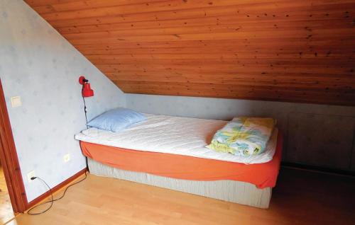 a small bed in a room with a wooden ceiling at Nice Home In Simrishamn With Kitchen in Simrishamn