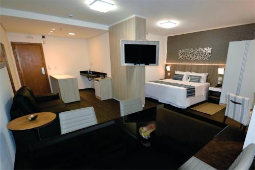 Uma TV ou centro de entretenimento em Allia Gran Pampulha Suites
