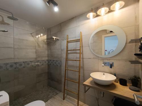 een badkamer met een wastafel en een spiegel bij Ferragood House - Historic Center in Ferragudo