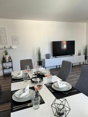 a dining room with a table with glasses of wine at Penthouse im Zentrum von Bregenz in Bregenz