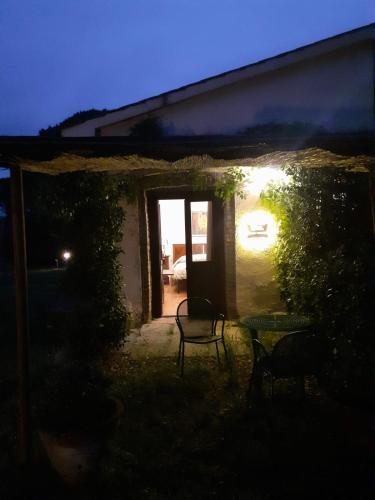 a house with a table and chairs in the yard at night at Borgo de' Muracci in Ribolla
