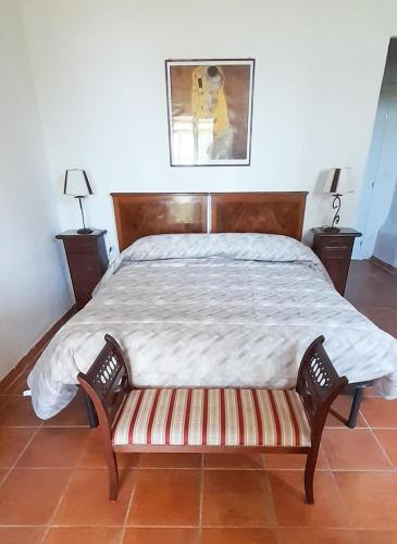 a bedroom with a large bed with a wooden headboard at Borgo de' Muracci in Ribolla