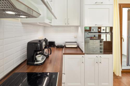 a kitchen with white cabinets and a coffee maker on a counter at Casa Luna D'Argento Corfu in Virós