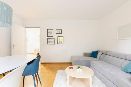 a living room with a couch and a table at Spacious 52 sqm Cozy Flat - Free Parking - 10 min to Lausanne Old Town in Lausanne