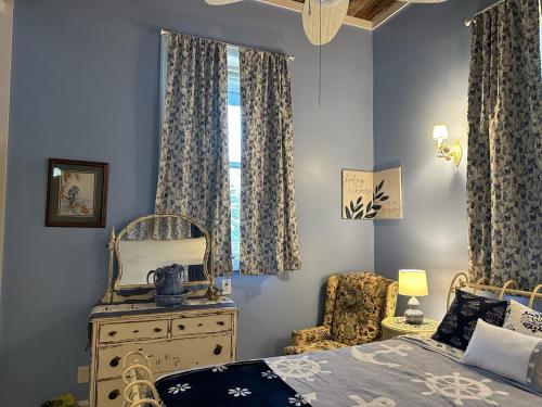 a bedroom with a bed and a dresser and a window at The Purple Martin Lakeside Inn Bird Sanctuary on Lake Huron in Rogers City