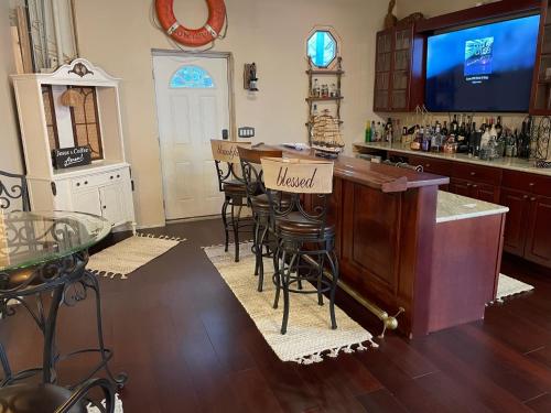 a kitchen with a bar with stools and a tv at The Purple Martin Lakeside Inn Bird Sanctuary on Lake Huron in Rogers City
