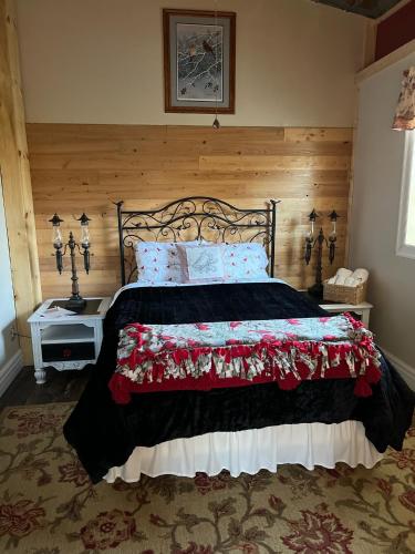 a bedroom with a large bed with a wooden headboard at The Purple Martin Lakeside Inn Bird Sanctuary on Lake Huron in Rogers City