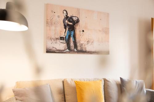a living room with a couch with a painting on the wall at Apartments an der Oper - Innenstadt - Zentral - Küche - Wifi - Powered by Ko-Living in Halle an der Saale