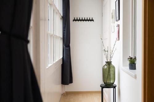 a vase on a table in a room with a window at Apartments an der Oper - Innenstadt - Zentral - Küche - Wifi - Powered by Ko-Living in Halle an der Saale