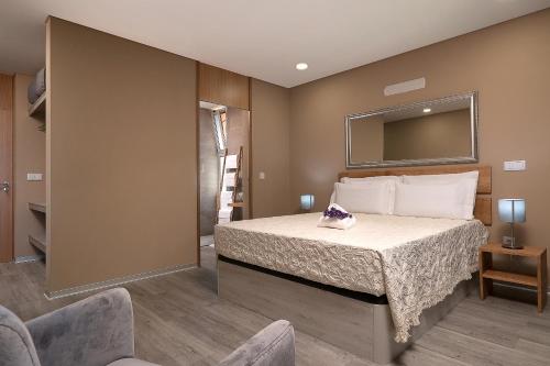 a bedroom with a bed with a mirror on the wall at Villa da Silva (Heated Pool and Private Parking) in Arco da Calheta