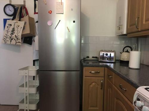 a kitchen with a stainless steel refrigerator in a kitchen at Entire 2 bed apartment - Up to 4 guest - 10 min from station and town centre in Wokingham