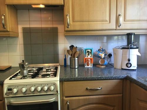 a kitchen with a stove and a counter top at Entire 2 bed apartment - Up to 4 guest - 10 min from station & town centre in Wokingham