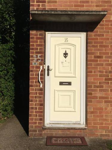 a white door on the side of a brick building at Entire 2 bed apartment - Up to 4 guest - 10 min from station & town centre in Wokingham