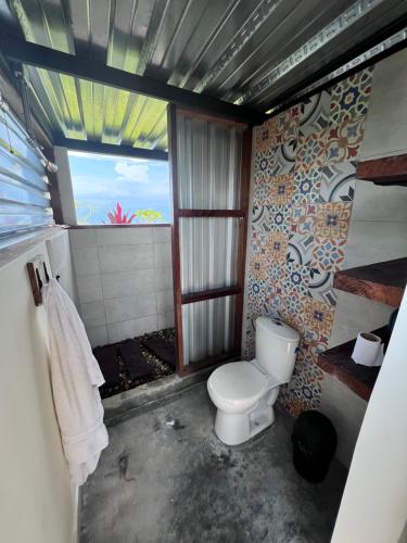 łazienka z toaletą i oknem w obiekcie El Filito w mieście San JosÃ©