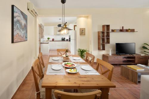 a dining room and kitchen with a wooden table and chairs at Casa Luna D'Argento Corfu in Virós