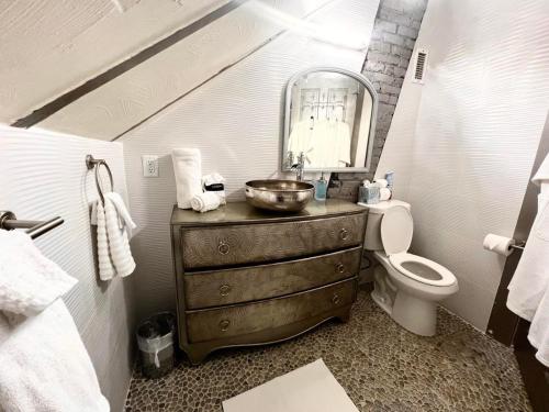 a bathroom with a sink and a toilet and a mirror at 1001 Nights Historic Bed and Breakfast Adults Only in Saint Augustine