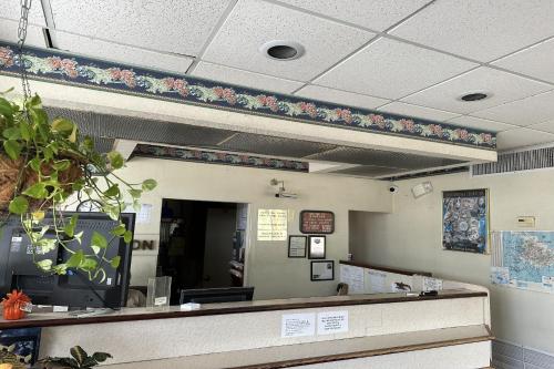 een wachtruimte van een wachtkamer met bloemen aan de muur bij Kampus Inn by OYO Gainesville - University Area in Gainesville