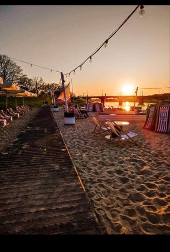 a beach with a bunch of chairs and the sunset at Night Host Trzebnicka 56/1 in Wrocław