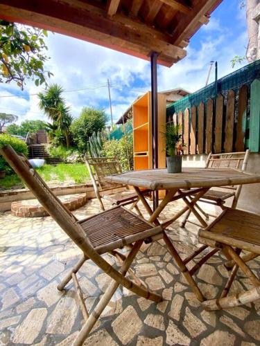 una mesa de madera y sillas en un patio en CasaMoltoCarina Cottage Garden, en Minturno