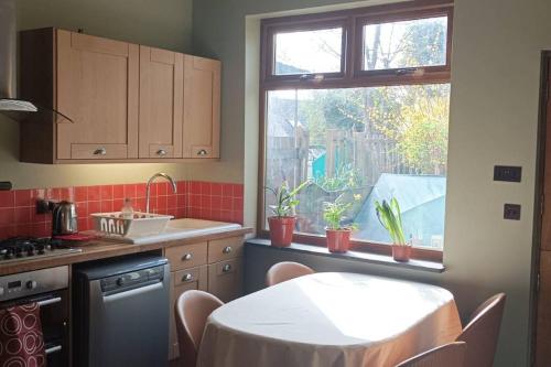 uma cozinha com uma mesa com cadeiras e uma janela em Ruskin Square, Sheffield em Heeley