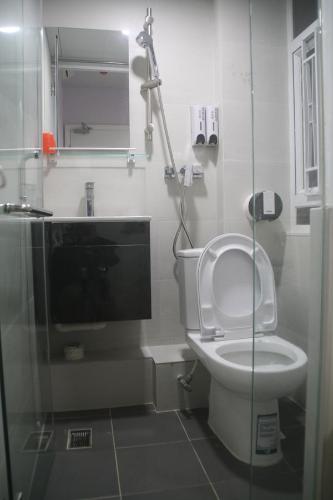 a bathroom with a toilet and a glass shower stall at K & B Hostel in Hong Kong