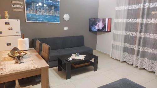 een woonkamer met een bank en een tafel bij Modern Apartment Kallithea 2 in Kallithea