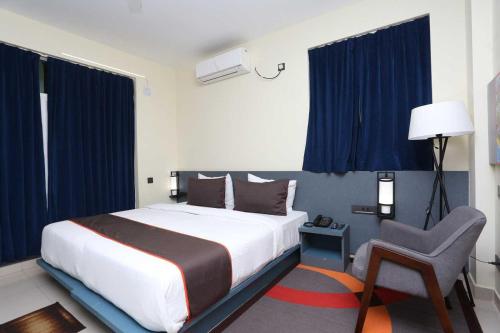 布巴內斯瓦爾的住宿－Hotel Vastukar Retreat，一间卧室配有一张大床和一把椅子