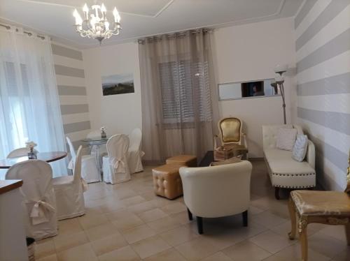 a living room with white chairs and a table at La Sosta in Lunigiana in Monti di Licciana Nardi