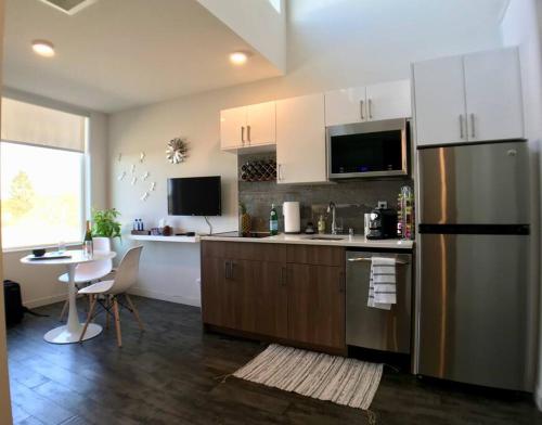 a kitchen with a stainless steel refrigerator and a table at Modern Capitol Hill Studio Steps to Volunteer Park in Seattle