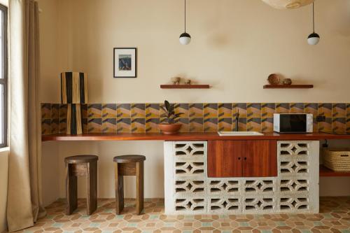 a kitchen with a counter with stools and a microwave at DUNA by DW in San Juan