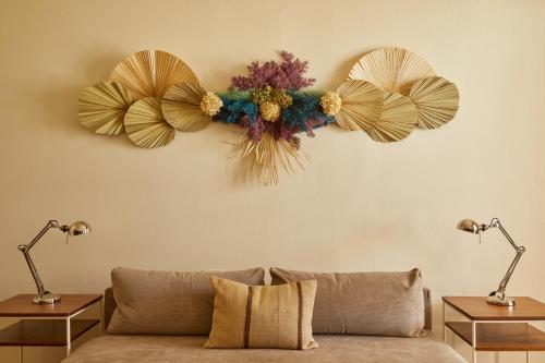 a living room with a couch and flowers on the wall at DUNA by DW in San Juan