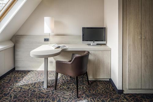 a hotel room with a desk with a computer and a chair at Fletcher Hotel-Restaurant De Broeierd-Enschede in Enschede