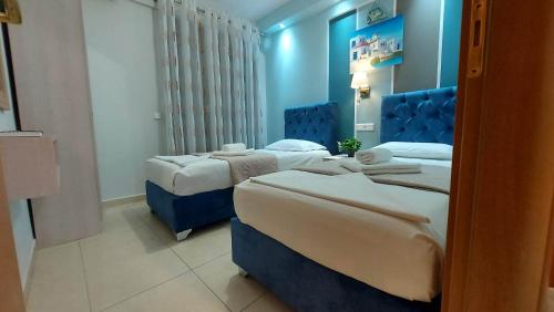 two beds in a room with blue walls at Modern Apartment Kallithea 2 in Kallithea Halkidikis