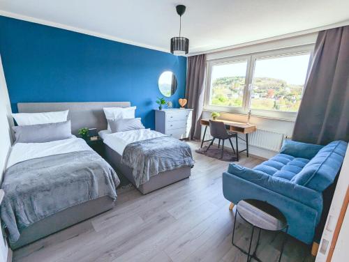 een slaapkamer met 2 bedden en een blauwe muur bij Modern flat with elevator/balcony/parking in Hagen