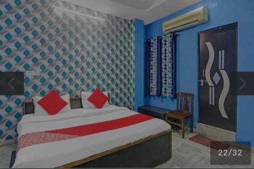 1 dormitorio con 1 cama con paredes azules y almohadas rojas en OYO 81043 Siva Guest House, en Lucknow