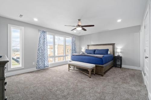 a bedroom with a blue bed and a ceiling fan at Upscale Downtown Condo W Outdoor Patio And Parking in Clarksville