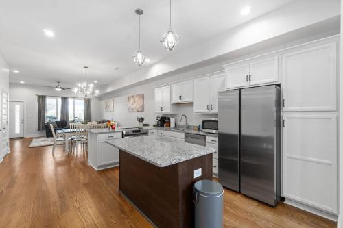 a kitchen with white cabinets and a stainless steel refrigerator at Rebecca's Downtown Luxury Living (527 N 1st St, #C) in Clarksville