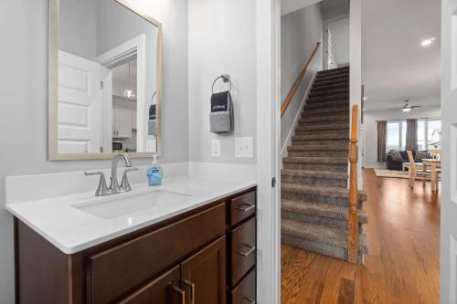 a bathroom with a sink and a mirror and a staircase at Upscale Downtown Condo W Outdoor Patio And Parking in Clarksville