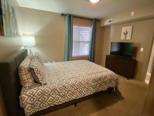 ein Schlafzimmer mit einem Bett und einem TV in der Unterkunft Lofts 206 - Cute And Cozy 1 Bedroom Loft in Clarksville