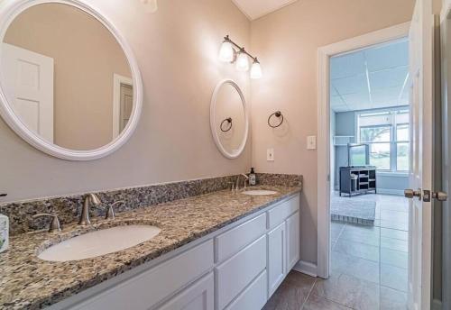 un bagno con due lavandini e un grande specchio di The Magnolia Suite At Hilltop Acres - Clarksville a Clarksville