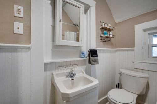 La salle de bains blanche est pourvue de toilettes et d'un lavabo. dans l'établissement Historic Condo 2,5 Blocks From Fm Bank Arena, à Clarksville
