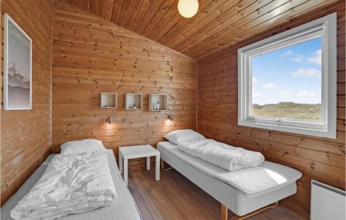 ヴィデ・サンデにあるAmazing Home In Hvide Sande With Indoor Swimming Poolのベッド2台と窓が備わる客室です。