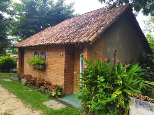 a small brick house with a tile roof at HOSTEL DAS ESTRELAS in Areal