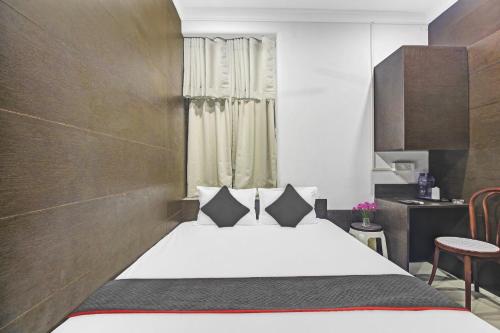 a bedroom with a bed and a table at Townhouse Centre Point Inn Near Esplanade Metro Station in Kolkata
