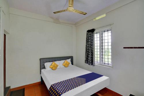 a bedroom with a bed with a ceiling fan at SPOT ON 81127 Ka Lodge in Muttam