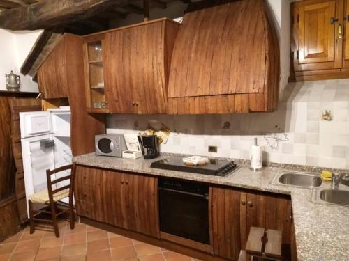 a kitchen with wooden cabinets and a stove top oven at Casa in Borgo Medievale in Toscana in Monterone