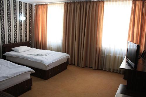 a hotel room with two beds and a television at Europa Hotel in Chişinău
