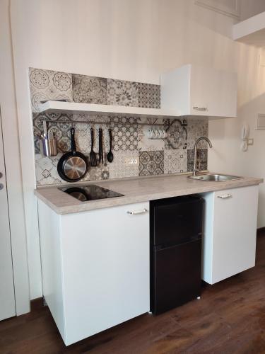 a white kitchen with a sink and a counter at Dimora Lina in Polignano a Mare